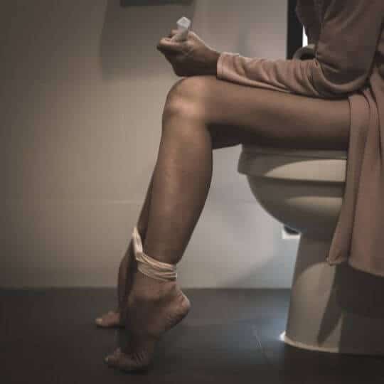 woman_sitting_on_chair_height_toilet.jpeg